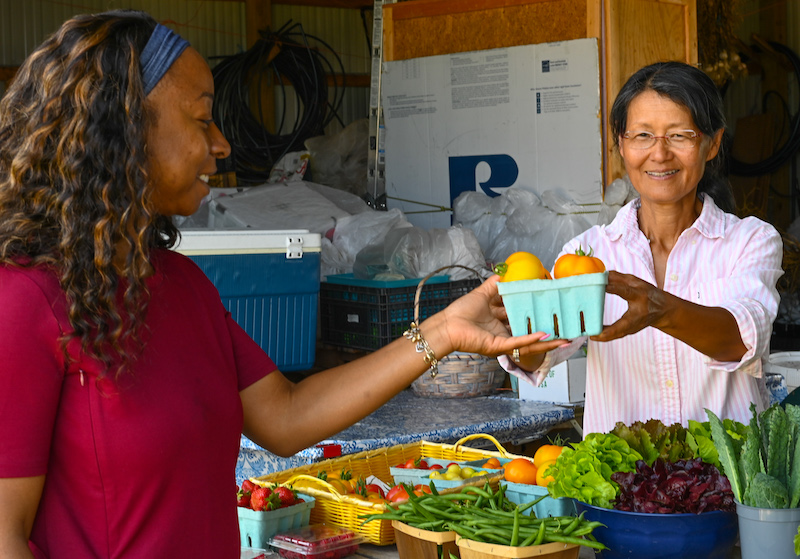 (R-L) Purple Skies Farm Owner Visar Duane shows NRCS District Conservationist Lynette Harmon heirloom tomatoes that she has grown on the farm